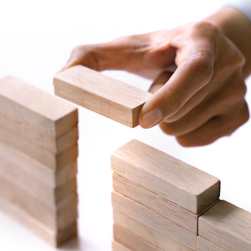 hand of people building up the wooden brick block bridge wall, Business risk and strategy concept.