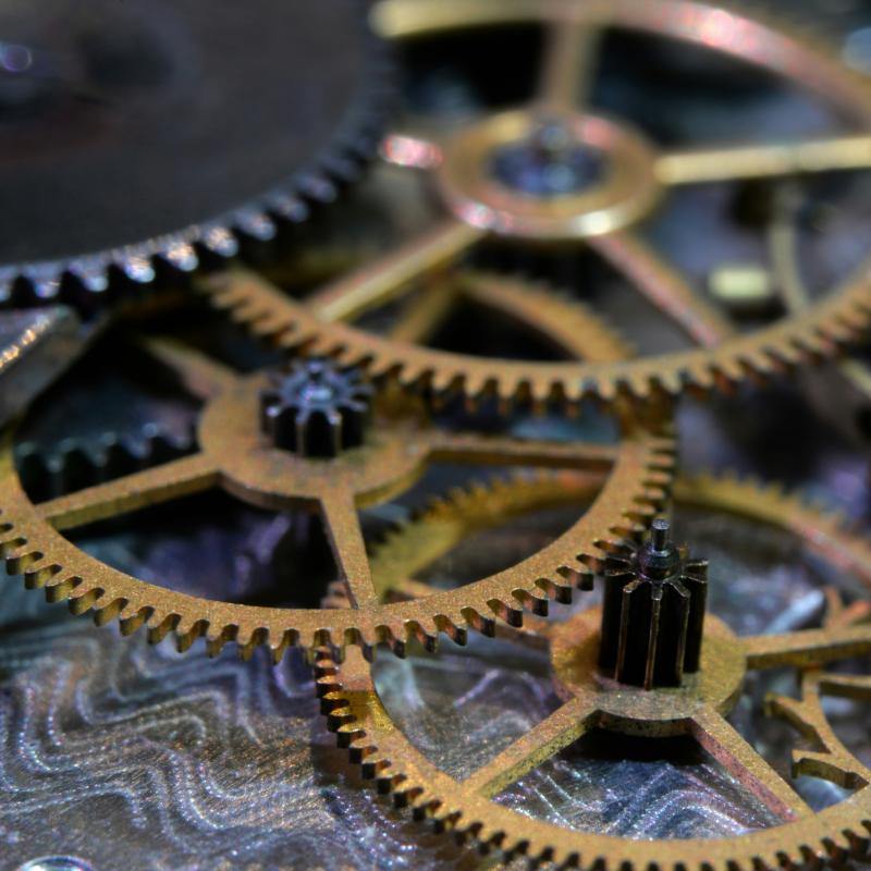 Photo of various gold colored gears laying on top of each other.