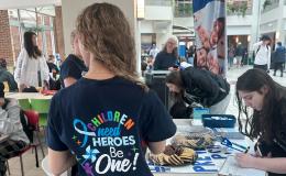 A student with long hair models the t-shirt for the event.