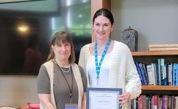 Deborah Ehrenthal, SSRI Director, and Kassidy McElwee, Research Project Manager, poses with her Above and Beyond Award.