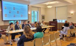 Group of panelists sits at the front for a discussion about research and collaboration.