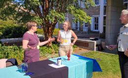 The Office of Research Protections table chats with attendees.