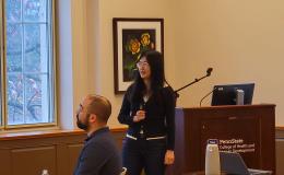Xue Zhang, an Asian woman wearing a dark sweater, presents to the group. 