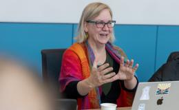 Jenny Van Hook, PRI Director, a woman wearing a brightly colored shawl, talks to the group.