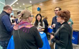 SSRI Open House attendees chatting around a high-top table.