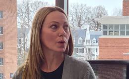 Linsday Wells, a woman with long blonde hair wearing a grey sweater, talks to the group.