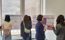Presenters from the Poster Session show off their posters.