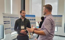 Presenters from the Poster Session show off their posters.