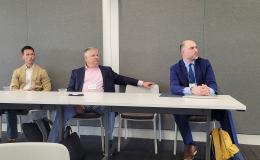Glenn Sterner, Dennis Scalon and Jonathan Larsen listen to Kristina Brant present.