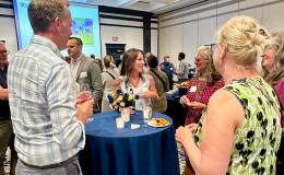 Attendees mingle at a high-top table.