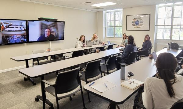 Wide shot of the Henderson conference room with Open House attendees.
