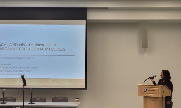 Neeraj Kaushal presents her research to the group.