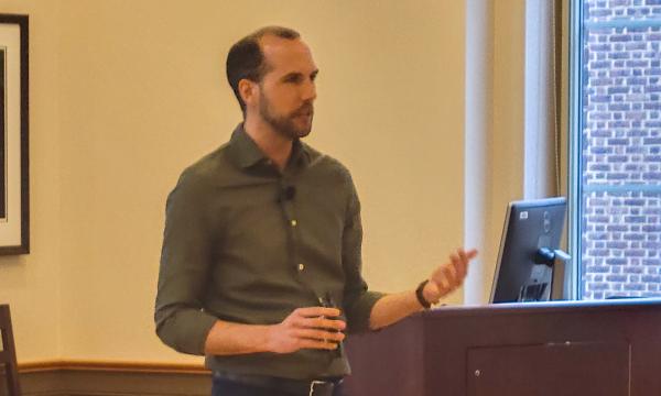 Blake Colainne talks to the group about the work Penn State is doing around mental health and flourishing of college students.
