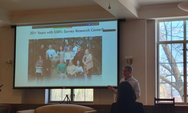 Dave Almeida, a white man in white shirt and brown pants, presents about working with SSRI's Survey Research Center.