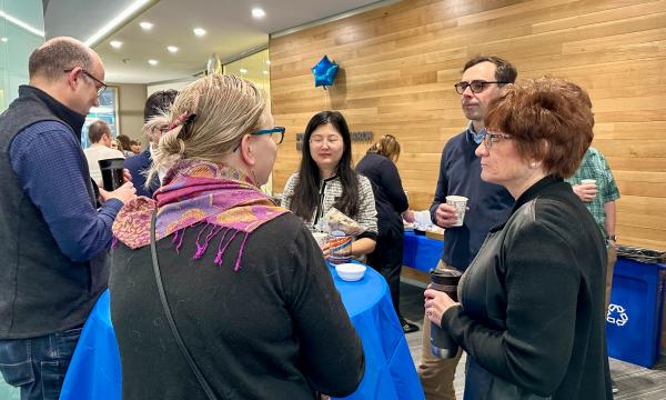 SSRI Open House attendees chatting around a high-top table.