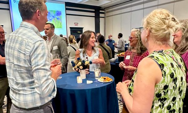 Attendees mingle at a high-top table.
