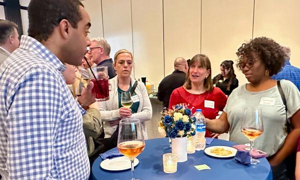 Attendees mingle at the high-top tables.