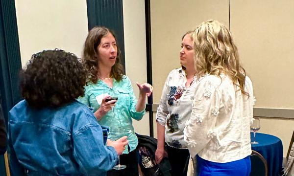 Attendees mingle at the high-top tables.